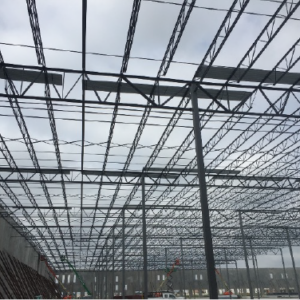 Open web steel joists and joist girders forming a roof framing system, with metal roof deck partially installed